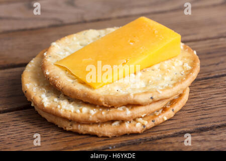 Tre golden formaggio crackers su legno. Con il formaggio. Foto Stock