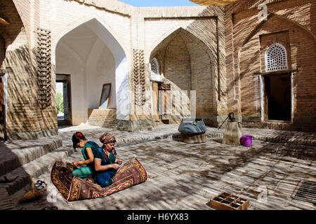 Khiva Workshop di seta,colorate, Suzanas,getta,copriletto,tappeti di seta,donne al lavoro,Silk Road,Khorezm provincia,Uzbekistan Foto Stock