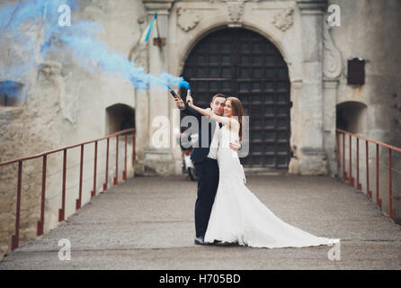 La sposa e lo sposo con fumo bombe sullo sfondo del castello Foto Stock