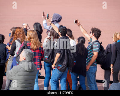 I turisti in attesa di una sfilata di Londra. I turisti scattare foto con macchine fotografiche e telefoni intelligenti durante l'attesa per la modifica di th Foto Stock