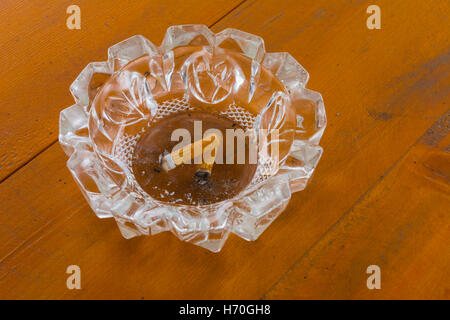 Posacenere sporchi con mozziconi di sigaretta sul tavolo Foto Stock