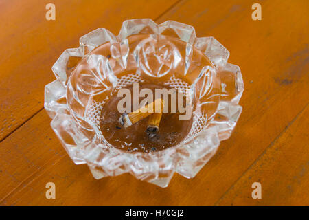 Posacenere sporchi con mozziconi di sigaretta sul tavolo Foto Stock