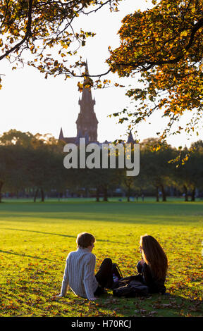 Gli studenti nei prati, Edimburgo, Scozia godono della bassa autunno come la luce del sole splende attraverso gli alberi in un giorno di novembre. Foto Stock