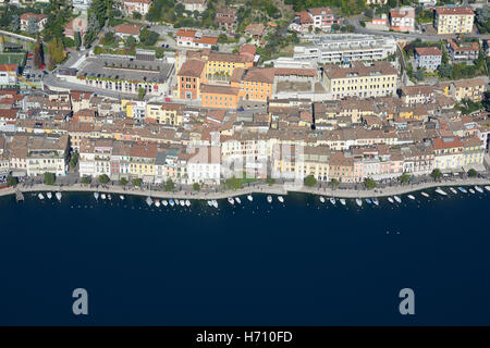 VISTA AEREA. Pittoresca cittadina con la sua fila di barche sul lago di Garda. Salò, Provincia di Brescia, Lombardia, Italia. Foto Stock