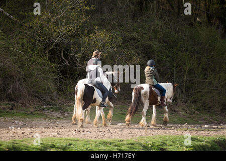 I bambini con pony con leader adulto Foto Stock