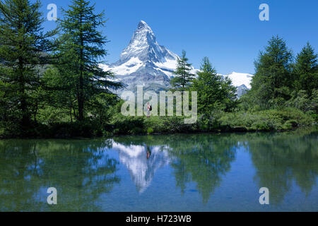 Escursionista e Cervino riflessa nella Grunsee, Zermatt, Pennine, Vallese, Svizzera. Foto Stock