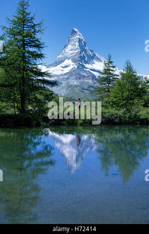 Escursionista e Cervino riflessa nella Grunsee, Zermatt, Pennine, Vallese, Svizzera. Foto Stock