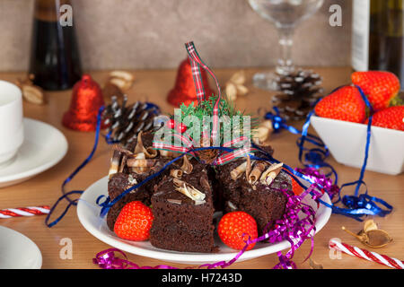 Festa di Natale tabella con torta al cioccolato e fragole condito con fantasie tartan nastro una berrys Foto Stock