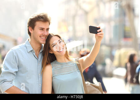 Coppia di turisti fotografare un selfie in una strada di città Foto Stock