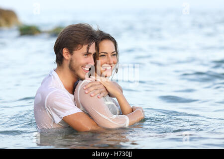 Coppia felice in amore abbracciando e balneazione in spiaggia Foto Stock