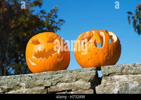 Due zucche di Halloween su una parete contro un cielo blu. Inghilterra, Regno Unito Foto Stock