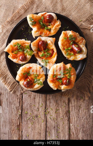 Focaccine farcite con salsiccia e formaggio su una piastra. vista verticale da sopra Foto Stock