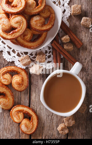 Caffè con latte e biscotti Palmiers sul tavolo. vista verticale da sopra Foto Stock