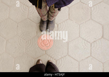 Immagine concettuale di gambe in stivali sulle strade Foto Stock