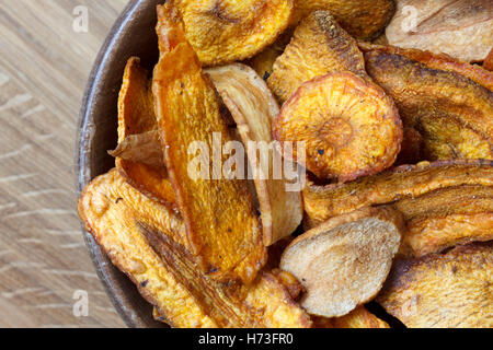 Dettaglio della frittura di carota e pastinaca trucioli in legno rustico ciotola. Foto Stock