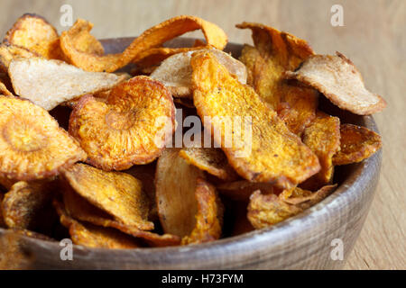 Dettaglio della frittura di carota e pastinaca trucioli in legno rustico ciotola. Foto Stock