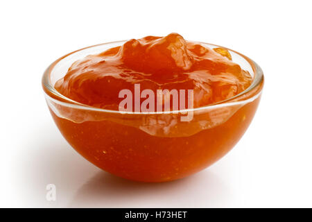 Piccolo ramekin di vetro di colore arancione albicocca isolato su bianco, in prospettiva. Foto Stock