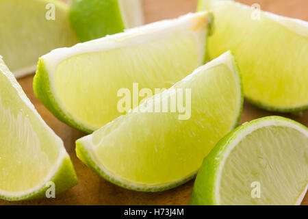 Spicchi di lime disposti su una tavola di legno. Messa a fuoco selettiva. Foto Stock