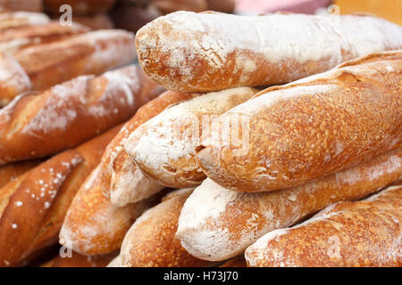 Molte pagnotte di pane impilati in un ambiente di mercato. Foto Stock