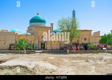 La strada del mercato con la coloratissima cupola di Pahlavon Mahmud mausoleo e Islam Khoja Minaret sullo sfondo Foto Stock