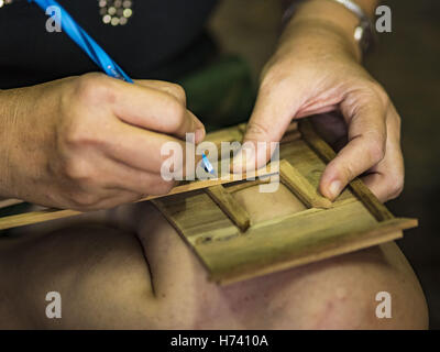 Bangkok, Bangkok, Thailandia. 2° Nov, 2016. Goccia, che ora gestisce il spirito di famiglia house workshop, misure a mano piccoli pezzi di legno di teak per l'uso sulla parete esterna di una casa degli spiriti. Vi utilizzata per essere di dieci famiglie che dallo spirito tradizionale case con legno di teak di Ban Fuen, una comunità vicino a Wat Suttharam in Khlong San distretto di Bangkok. La zona è stata gentrified e molti dello spirito casa politici hanno spostato in fuori, loro tradizionali case thai in legno, sostituite da moderni appartamenti. Ora non vi è una sola famiglia rendendo l'elaborato spirito case. Lo spirito case sono fatte a mano. Esso ta Foto Stock