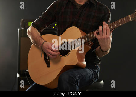 Close up uomo amplificato suonare la chitarra acustica Foto Stock