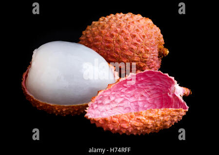 Unico litchi con la pelle rimosso e carne. Sul nero. Foto Stock