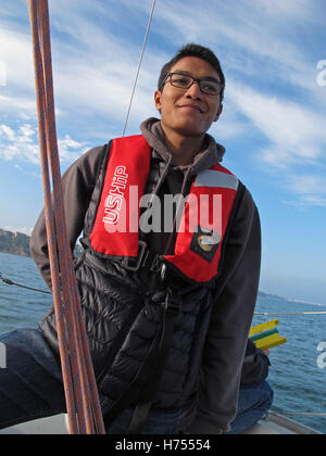 Giovane uomo al timone di una barca a vela, Binic ,Cotes-d'Armor, Bretagne, Bretagna Francia Foto Stock