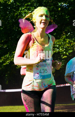 Un runner in una carità (Julian House) Colore della Fun Run tenutasi a Oldbury Court Estate, Bristol, Ottobre 2016 Foto Stock