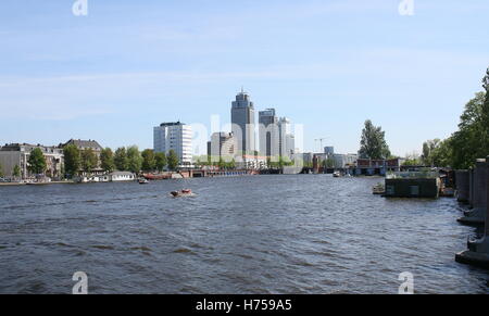 Ampia centrale sul fiume Amstel guardando verso Rembrandttoren (Rembrand torre), il grattacielo più alto di Amsterdam, Paesi Bassi Foto Stock