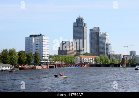 Fiume Amstel guardando verso Rembrandttoren (Rembrand torre), il grattacielo più alto di Amsterdam, Paesi Bassi Foto Stock