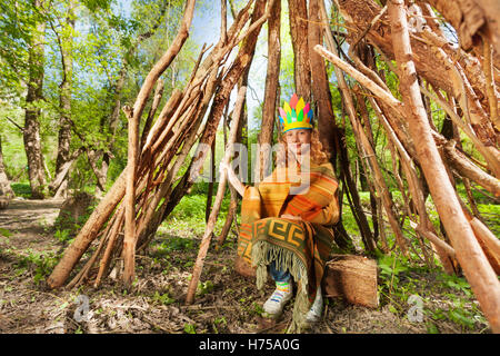 Felice ragazza che gioca Red Indian in seduta wigwam Foto Stock