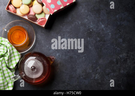 Tazza da caffè, teiera e amaretti confezione regalo sul tavolo di pietra. Vista da sopra con lo spazio di copia Foto Stock