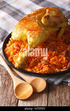 Kabsa - riso piccante con le verdure e il pollo su un piatto di close-up verticale. Foto Stock