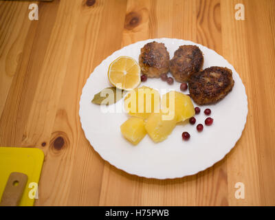 Wiener Schnitzel e patate bollite con spicchi di limone Foto Stock