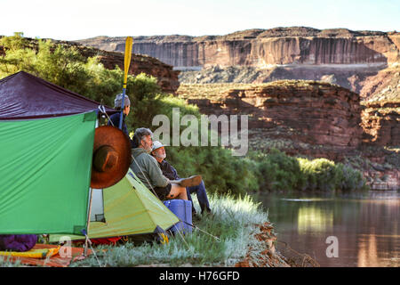 Un multi-generazionale famiglia di naviganti si affaccia dalla loro campeggio presso il fiume verde nel Parco Nazionale di Canyonlands, Utah Foto Stock