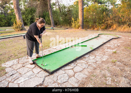 Donna che gioca outdoor golf in miniatura in una foresta di Galilea nel nord di Israele Foto Stock