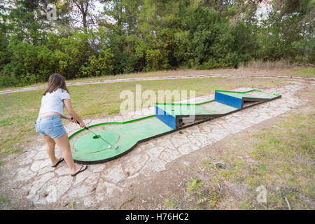 Ragazza adolescente giocando outdoor golf in miniatura in una foresta di Galilea nel nord di Israele Foto Stock