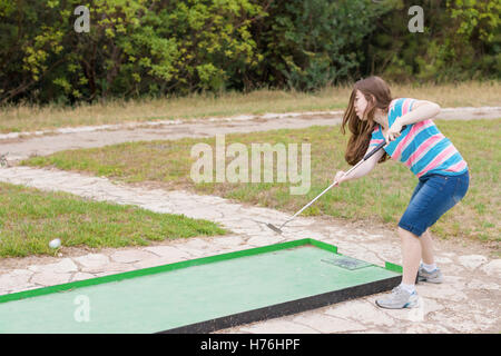 Giovane donna giocando outdoor golf in miniatura in una foresta di Galilea nel nord di Israele Foto Stock