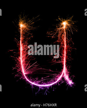 Sparkler fuochi d' artificio alfabeto di luce u (piccole lettere) di notte sullo sfondo Foto Stock