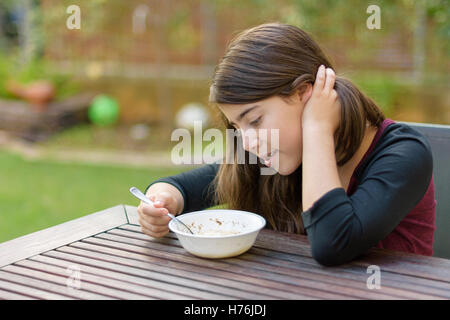 Una ragazza adolescente con rinforzi su i suoi denti godendo di calda zuppa di pollo (a.k.a. la penicillina ebraica) in una fredda giornata autunnale Foto Stock