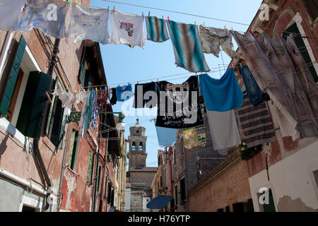 Appendere le linee di lavaggio asciugatura attraverso la steet e con la Chiesa di San Giuseppe di Castello in background in Venezia Foto Stock