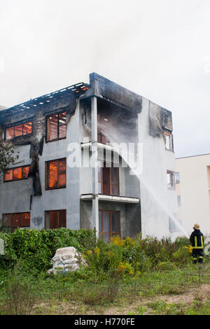 Vigile del fuoco contro un incendio con un tubo flessibile di acqua Foto Stock