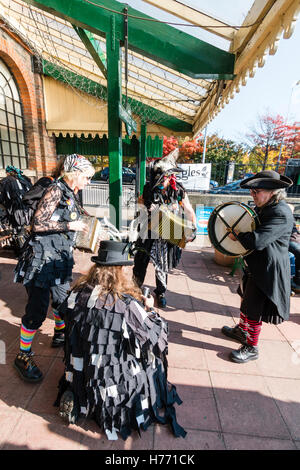 Inghilterra, Tunbridge Wells. Il Gong spugnette maniaco Morris lato, quattro membri della band esecuzione di fronte alla vecchia stazione ferroviaria. Foto Stock