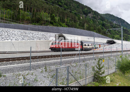 Ffs viaggiatori treno con un rosso Re 460 locomotiva parte il 57 km lungo la galleria di base del San Gottardo presso il portale nord di Erstfeld, Svizzera. Foto Stock