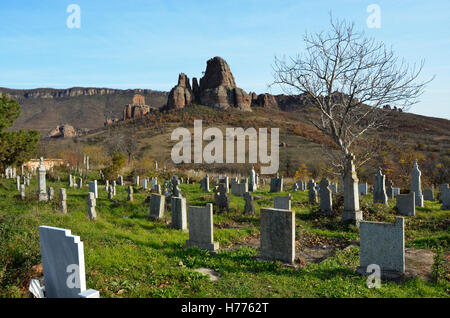 Graveyard and dead tree with rocky hill n background Foto Stock