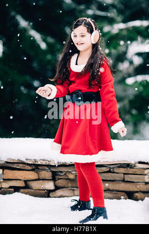 Ragazza sorridente in Christmas Santa outfit Dancing in the snow Foto Stock