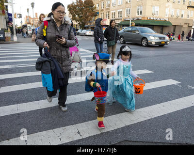 Giovani, Cinese ingann-o-treaters tenere mani come essi cross street su Halloween nella sezione di Bensonhurst di Brooklyn, NY, 2016. Foto Stock