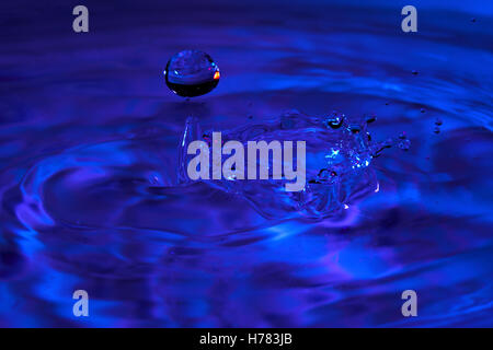 Goccia cade in acqua crescente ondata Foto Stock