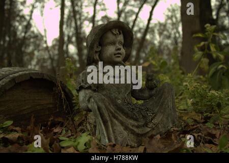 Le antiche rovine di un giardino ragazza statua in un giardino sovradimensionate Foto Stock